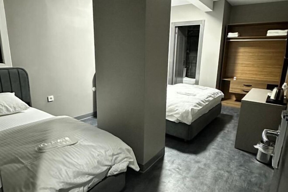Ein Hotelzimmer mit zwei Betten, einem kleinen Schreibtisch und einem Kleiderschrank.