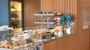 A breakfast buffet with various pastries and desserts displayed on glass shelves. - Kiss Beachfront Hotel & Restaurant (Cervia)