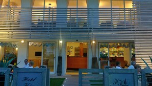 A hotel entrance with a double door, a signboard, and a pathway leading to the entrance. - Kiss Beachfront Hotel & Restaurant (Cervia)