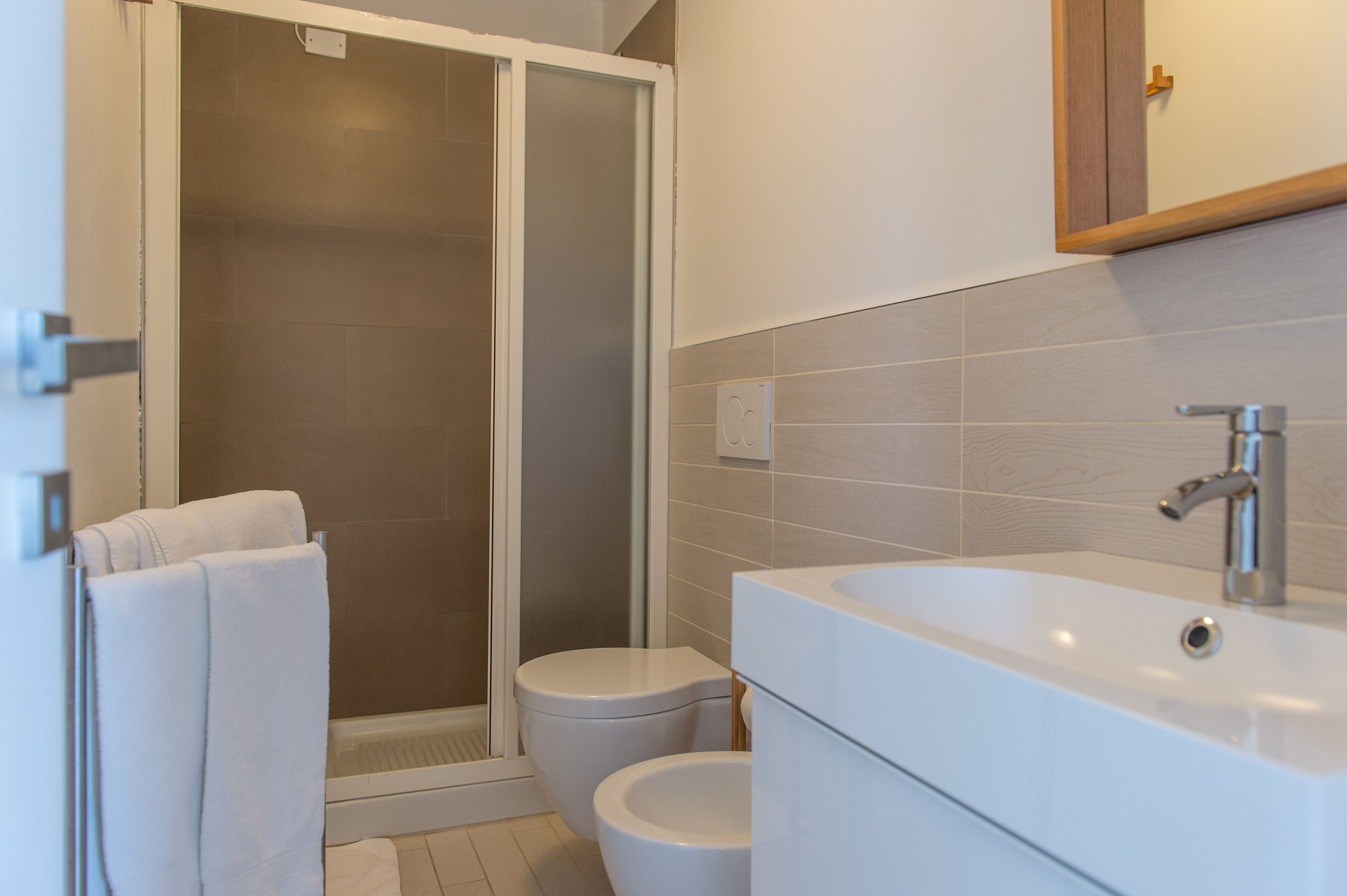 A modern bathroom with a shower, toilet, and sink.