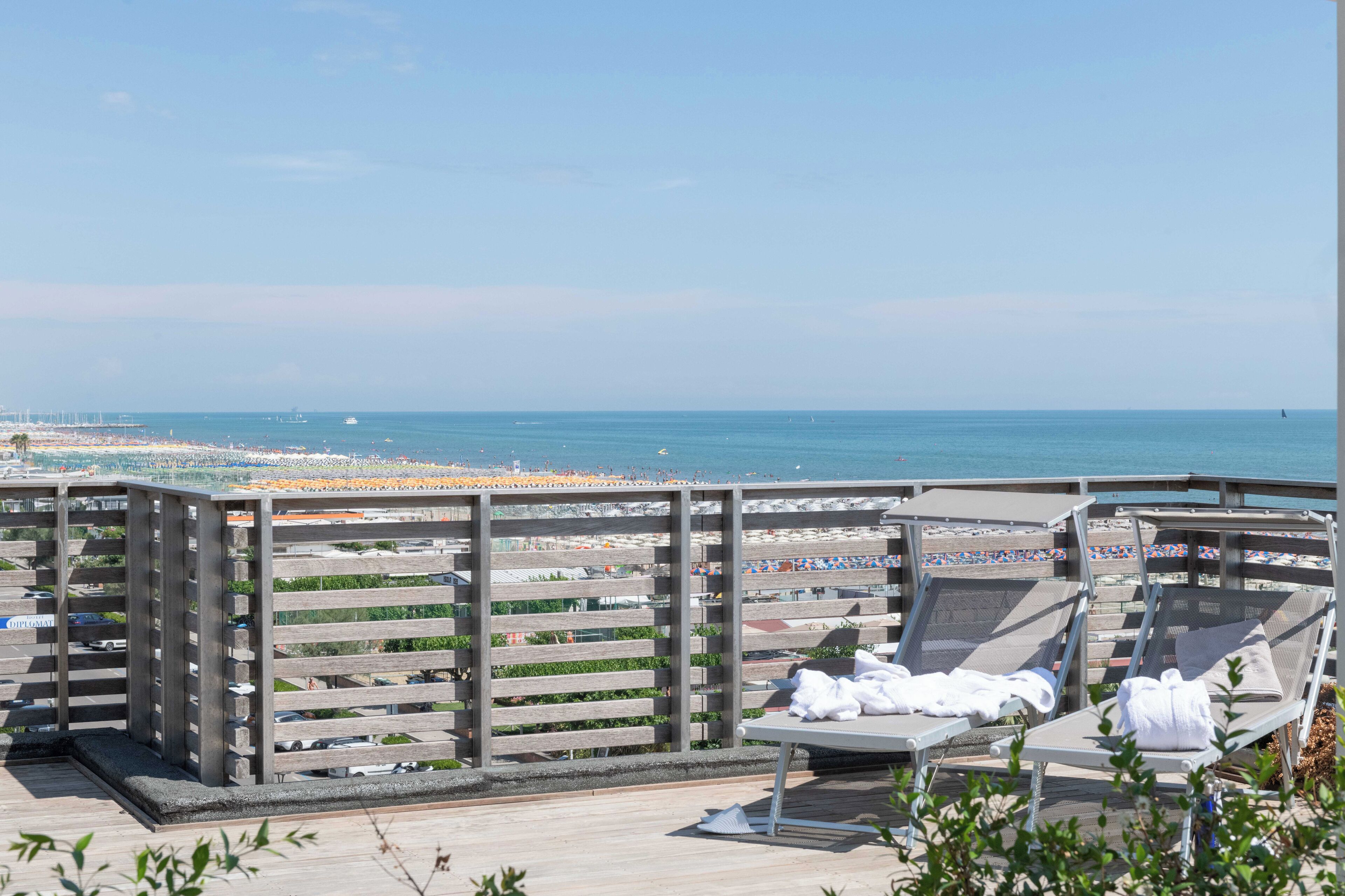 Une terrasse sur le toit, dotée de chaises longues et offrant une vue sur la plage.