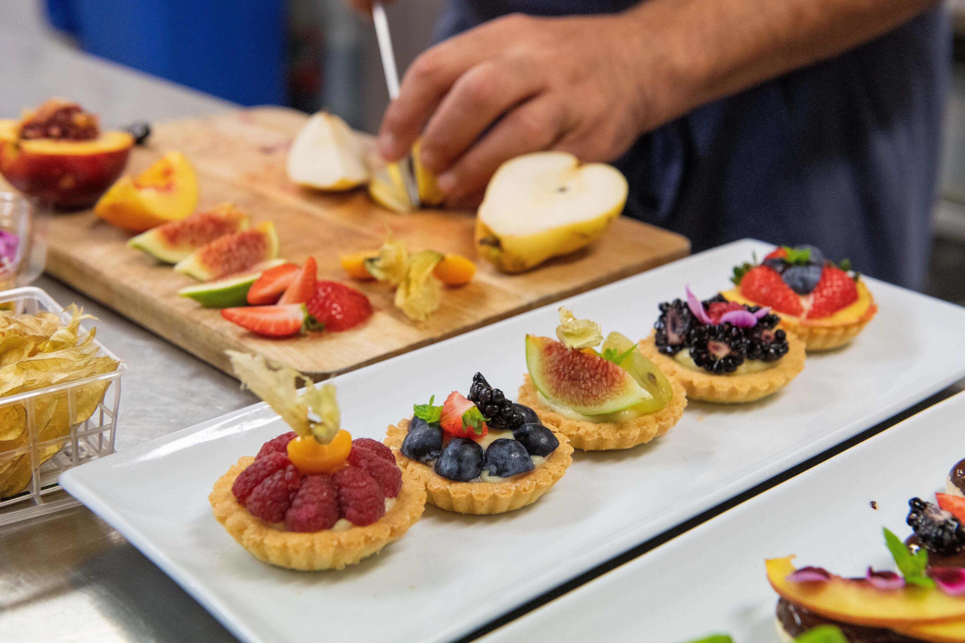 A variety of fruit tarts on a serving tray.