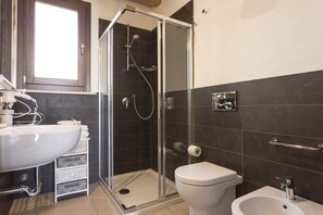 Een douche, een haardroger, een bidet, handdoeken
