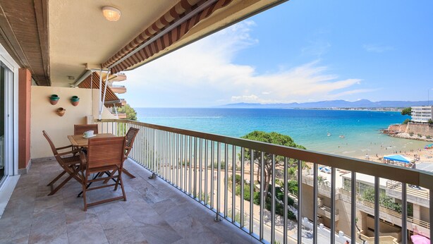 A balcony with a view of the sea, a table with chairs, and a railing. - UHC SOROLLA APARTMENTS (Salou)
