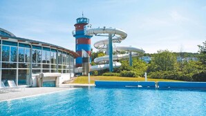 Une piscine avec un toboggan et une structure en forme de phare.