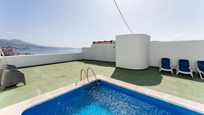 A rooftop pool with a view of the city and mountains, lounge chairs, and a pool ladder. - Apartment 'Penthouse with private pool' with Sea View, Wi-Fi and Air Conditioning (Malaga)