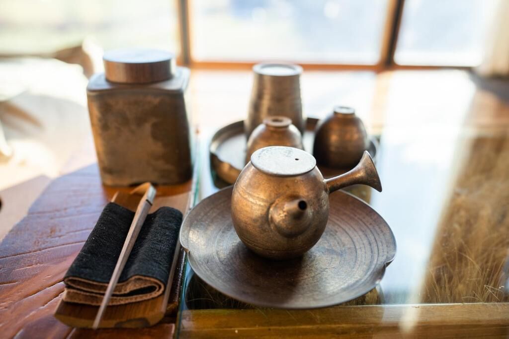 Un juego de té sobre una mesa de madera con una ventana al fondo.