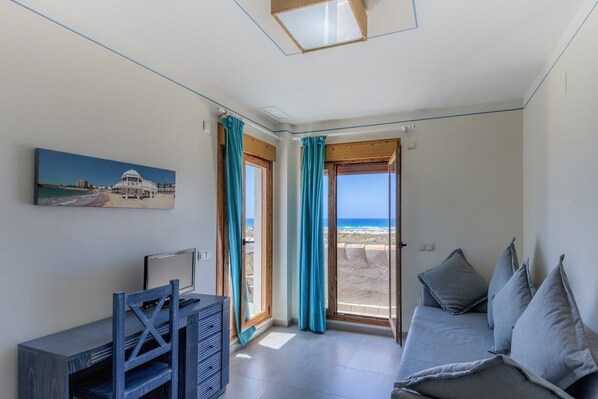 Panorama studio suite, 1 tweepersoonsbed met slaapbank, uitzicht op zee | Woonruimte | Een 24-inch flatscreentelevisie met digitale zenders en televisie