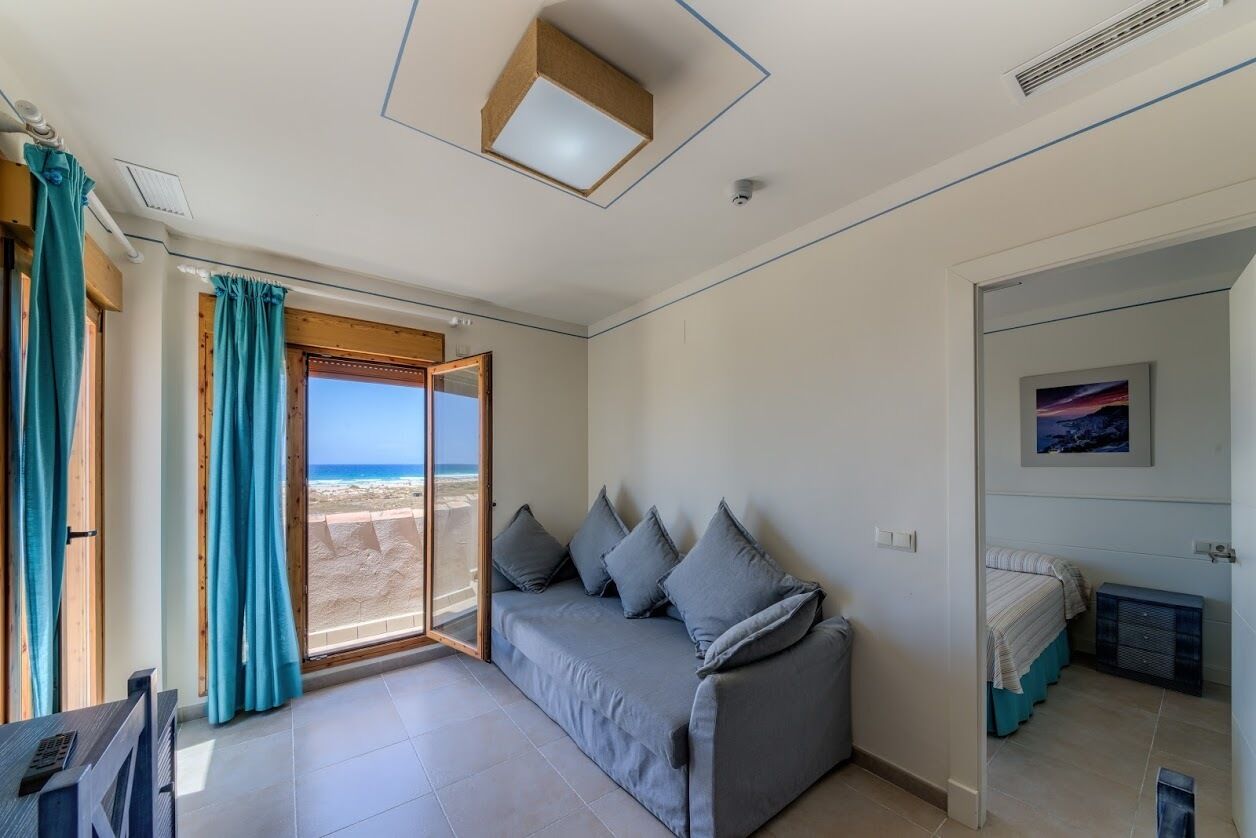 Suite estudio panorámica, 1 cama doble con sofá cama, vistas al mar | Zona de estar | Televisión de pantalla plana de 24 pulgadas con canales digitales