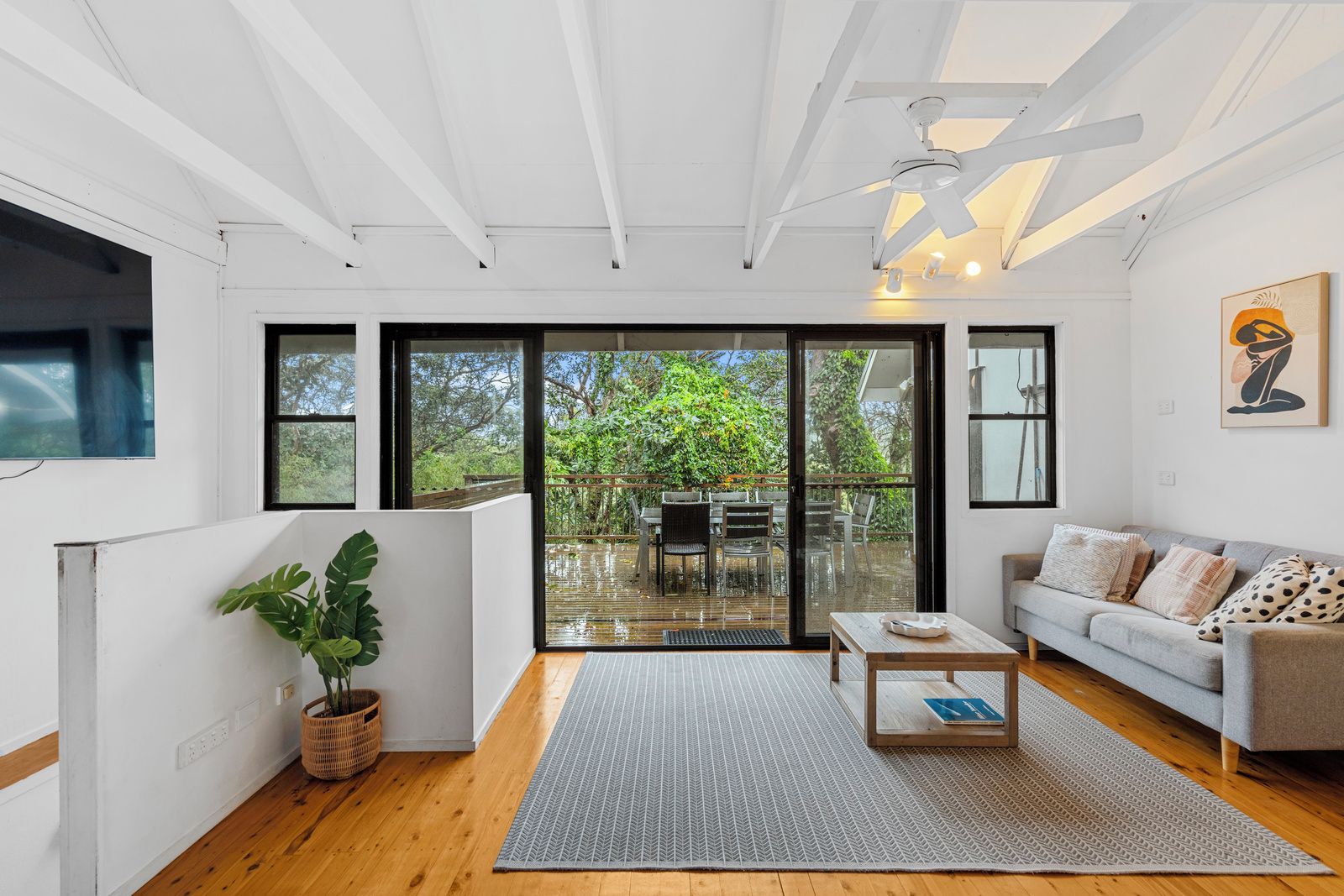 Una sala de estar moderna con un sofá, una mesa de centro y vistas a una terraza exterior.