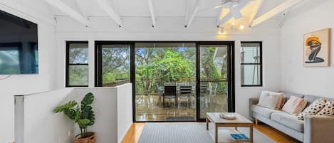 Una sala de estar moderna con un sofá, una mesa de centro y vistas a una terraza exterior.