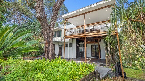 A two-story house with a balcony, surrounded by lush greenery and trees. - 20 Yarrong Rd - a very large house split over three levels (Point Lookout)