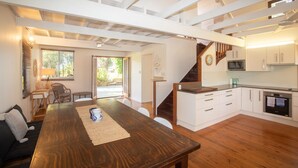 A modern kitchen with white cabinets, a wooden countertop, and a built-in oven. - 20 Yarrong Rd - a very large house split over three levels (Point Lookout)