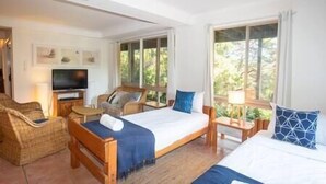 A hotel room with two beds, a TV, and a seating area. - 20 Yarrong Rd - a very large house split over three levels (Point Lookout)