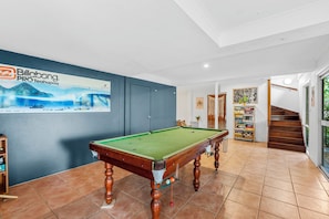 A billiards table in a room with a blue wall, a staircase, and a bookshelf. - 20 Yarrong Rd - a very large house split over three levels (Point Lookout)