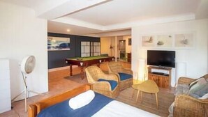 A hotel room with a pool table, two sofas, a television, and a bed. - 20 Yarrong Rd - a very large house split over three levels (Point Lookout)