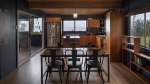A modern kitchen with a large island, wooden cabinets, and a view of the ocean. - Norm’s Place - a secluded, unique, absolute water front property at Amity Point (Amity Point)