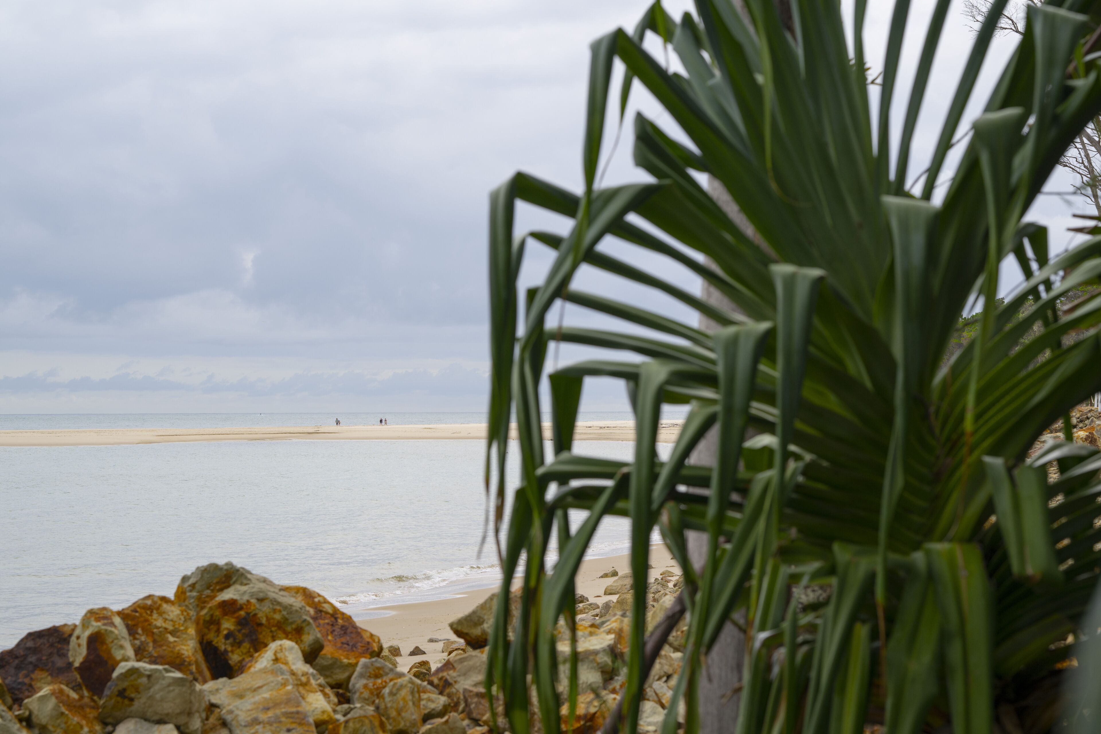 A beach with rocky foreground and a view of the sea.
