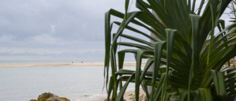 A beach with rocky foreground and a view of the sea.
