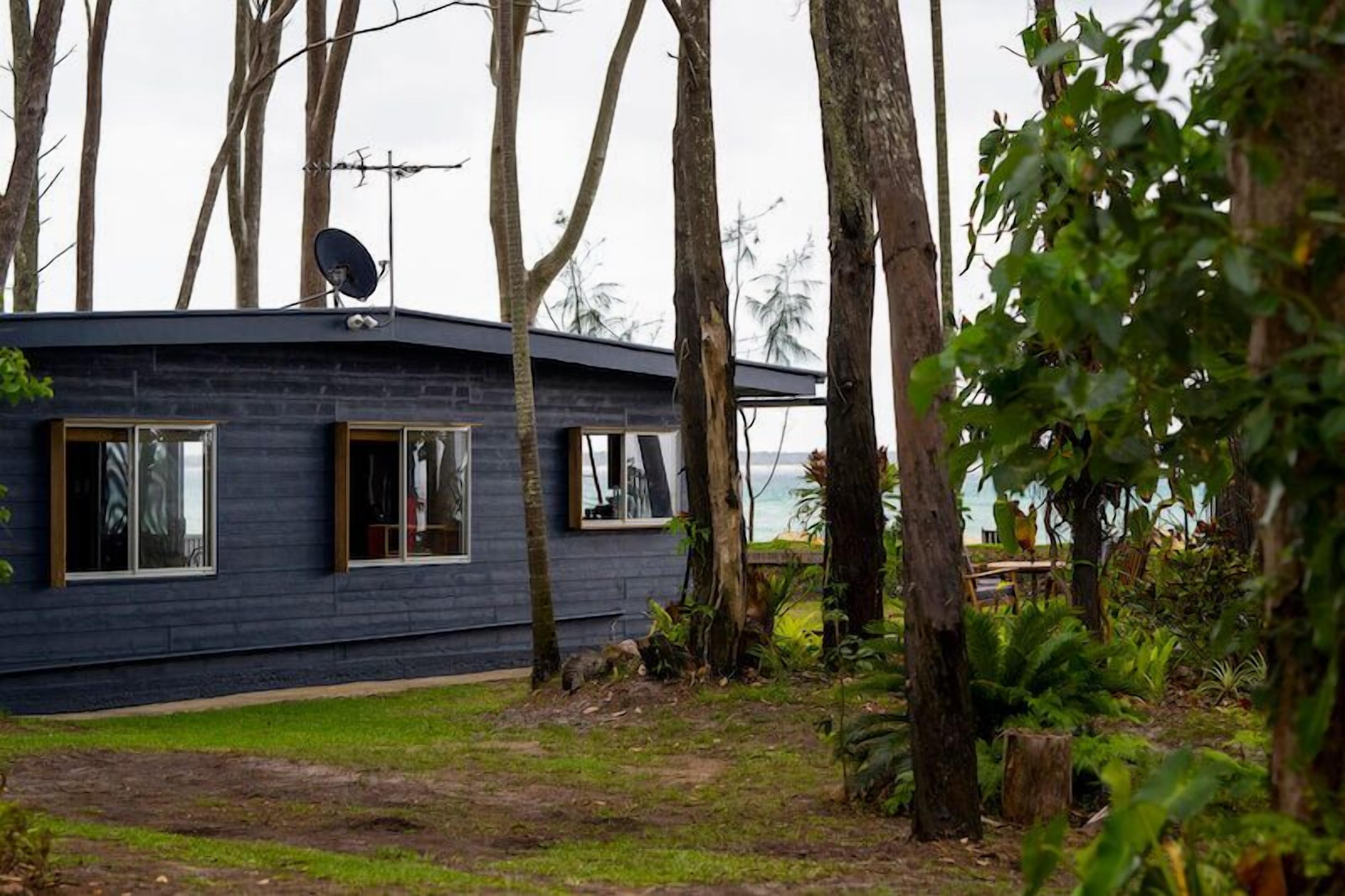 A cabin with a satellite dish, large windows, and a view of the ocean.