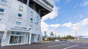 A hotel building with a sign reading "HOTEL AreaOne Sakamino Marina".