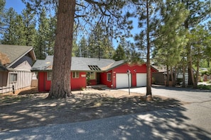A two-story house with a red exterior, a garage, and a driveway.