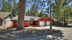 A red building with a garage, surrounded by trees.