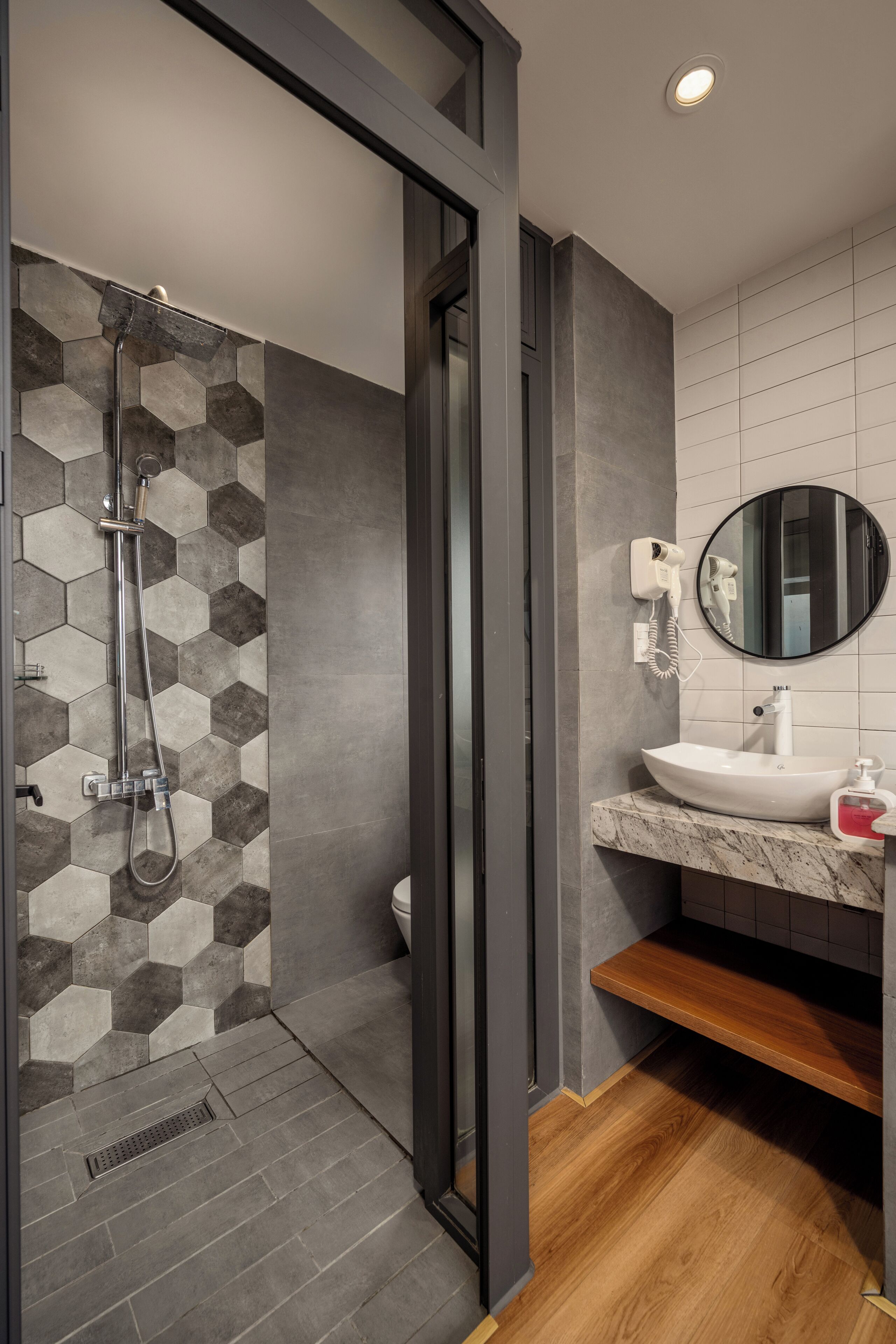 A modern bathroom with a shower, a sink, and a mirror.