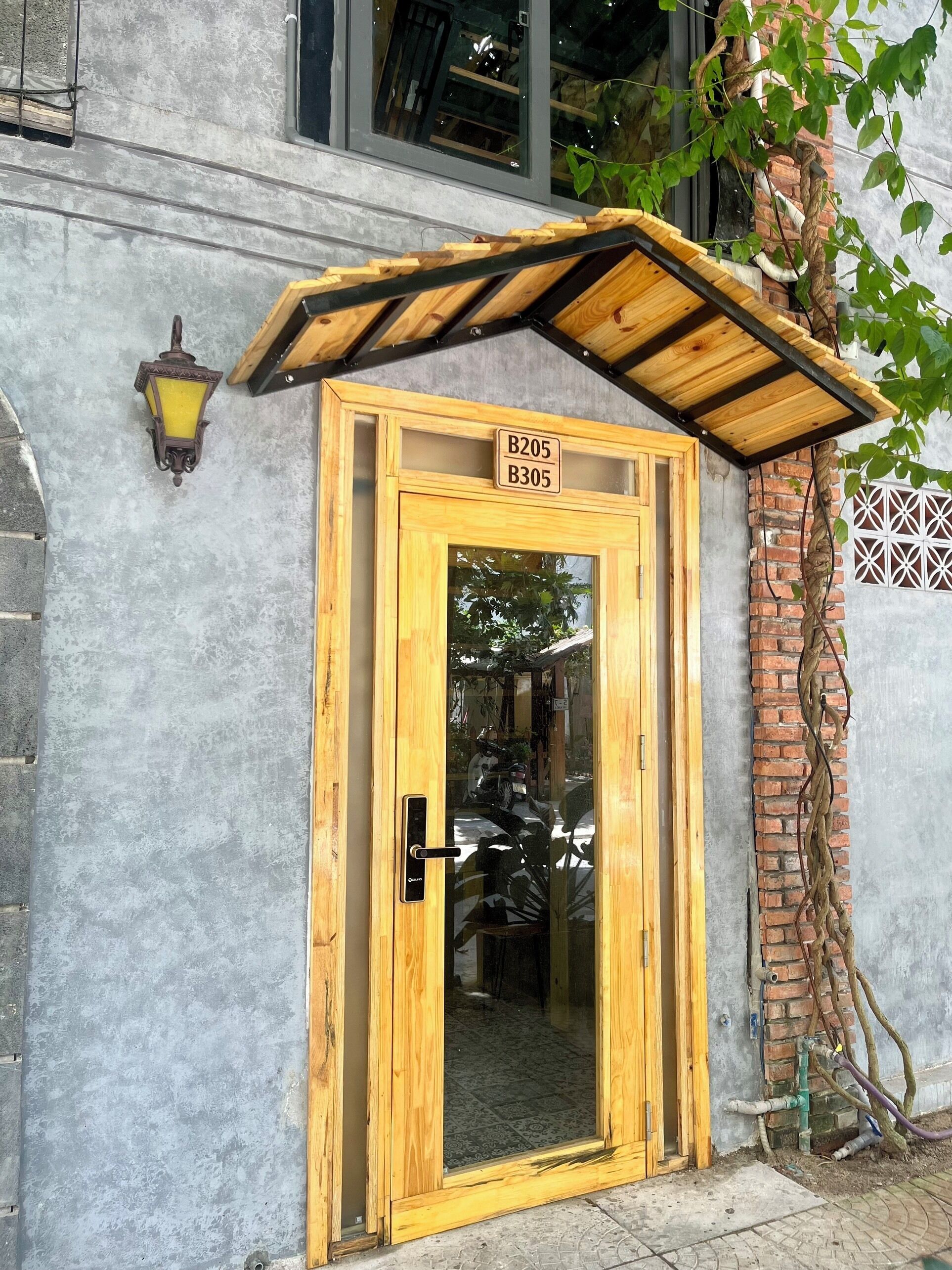 A wooden door with a glass panel, a small overhang, and a sign above it.
