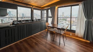 Une cuisine moderne avec un plafond en bois, de grandes fenêtres et une vue sur la ville.