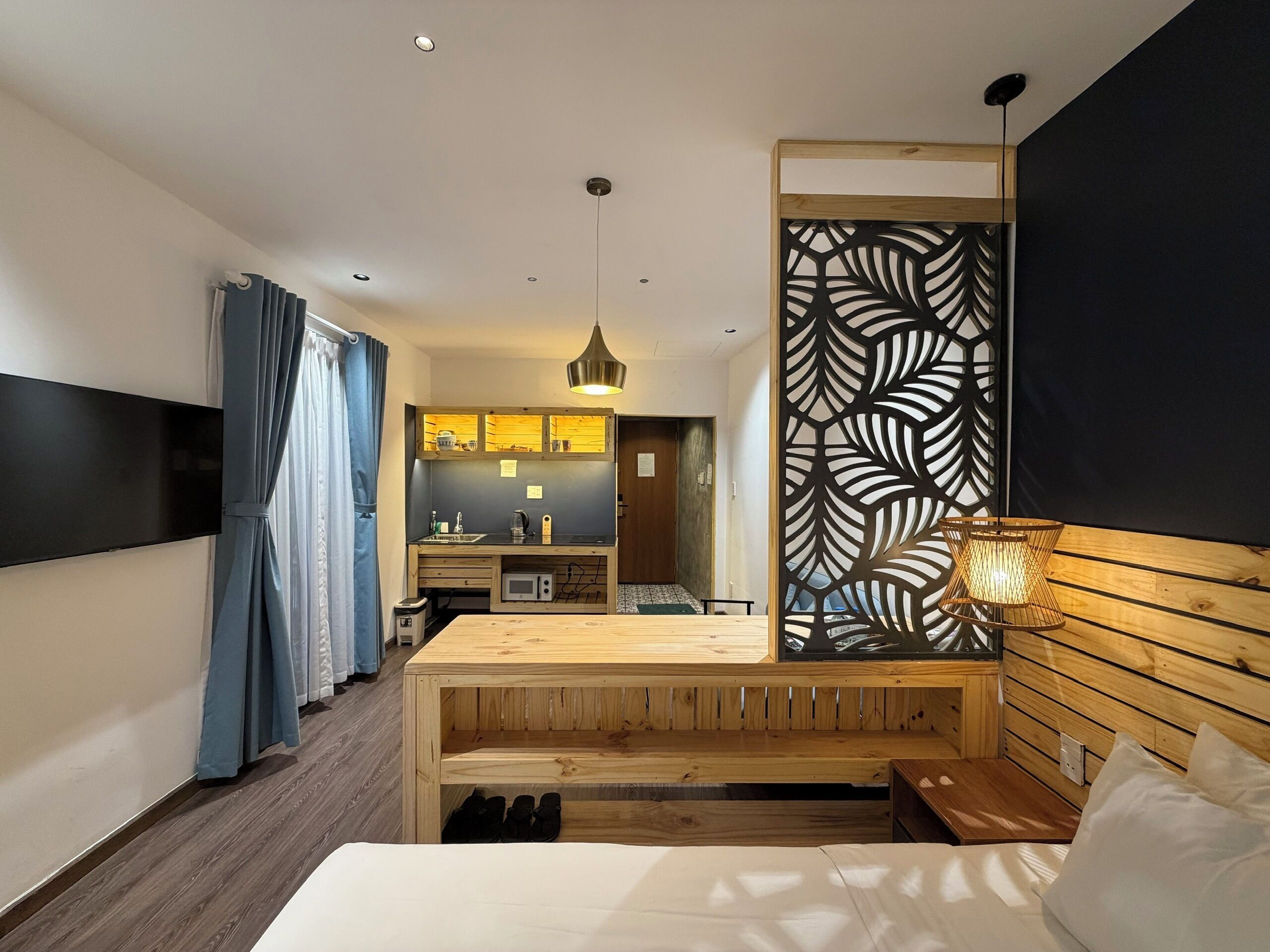 A modern bedroom with a wooden headboard, a bed, a bedside table, and a built-in bench.