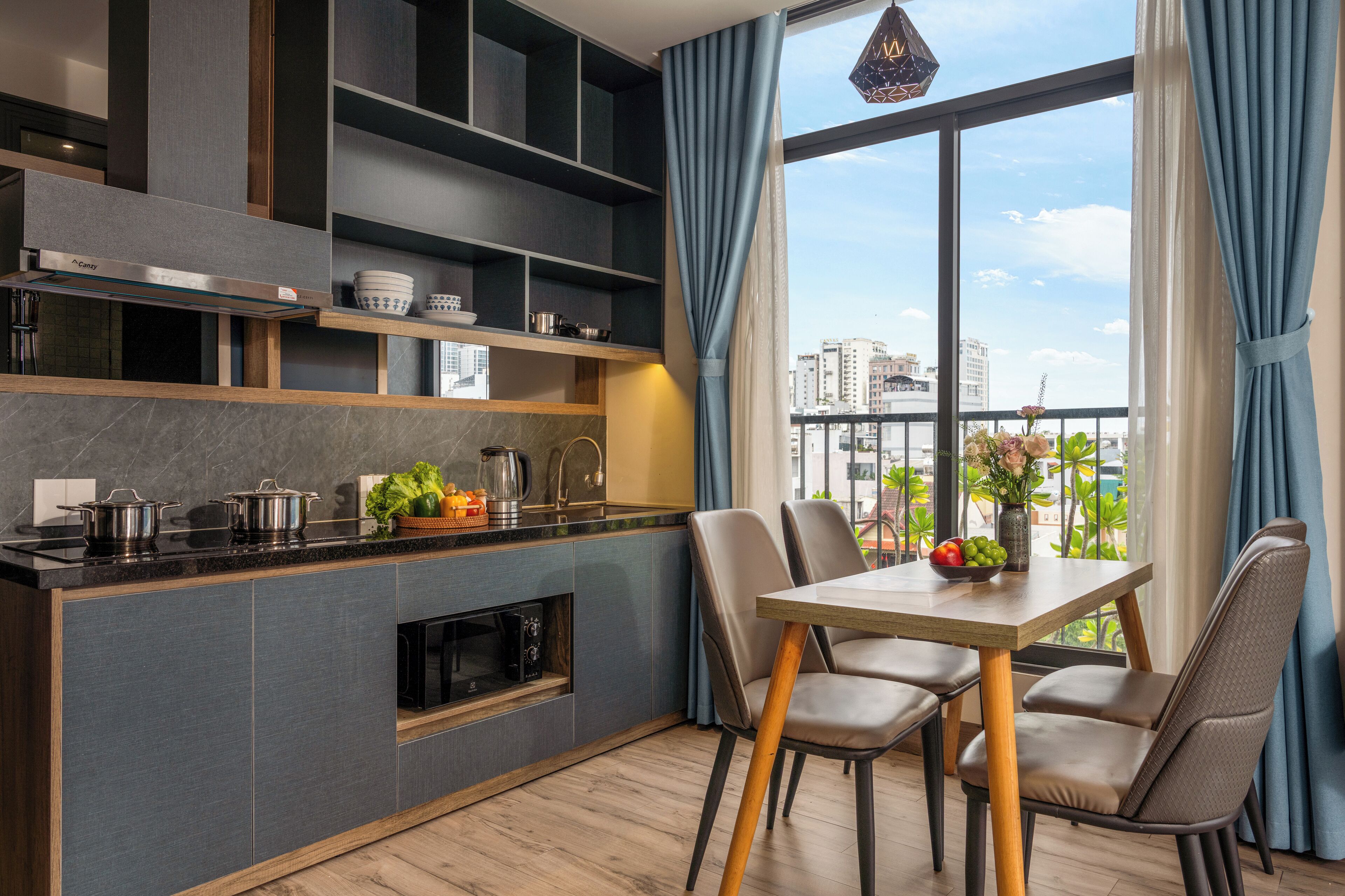 Eine moderne Küche mit Einbauregalen, ein Essbereich mit Tisch und Stühlen sowie ein großes Fenster mit Blick auf die Stadt.