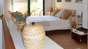 A bedroom with a bed, bedside table, lamp, and a view of the outdoors. - Atenas Jávea (Jávea)