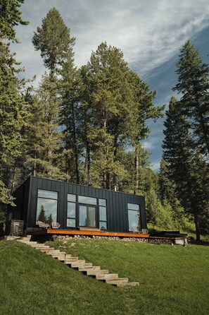 A modern house with a flat roof, large windows, and a wooden deck.