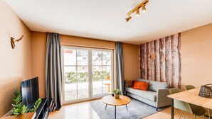 Ein modernes Wohnzimmer mit einer Couch, einem Couchtisch und einem Fernseher.