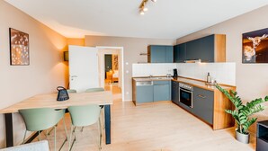 Eine moderne Küche mit Holzarbeitsplatte, Geschirrspüler und Spüle. Es gibt einen Essbereich mit Tisch und Stühlen.