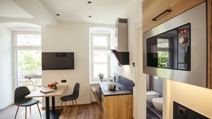 Una cucina moderna con forno integrato, un'area pranzo con tavolo e sedie, e vista all'esterno attraverso una finestra.