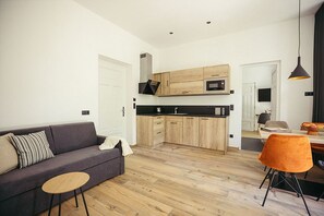 A modern kitchen with wooden cabinets, a black countertop, and a built-in microwave.