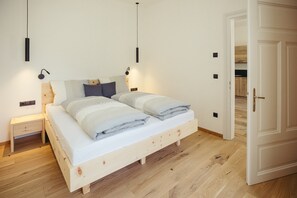 Ein Schlafzimmer mit einem hölzernen Bett, Nachttischen und einem Kleiderschrank.