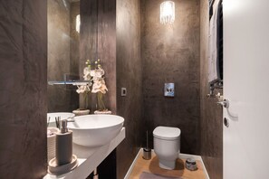 A modern bathroom with a large white sink, a toilet, and a mirror. - La Cala Terrace by Domusicily (Palermo)