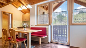 A wooden interior with a dining table, chairs, and a bench.