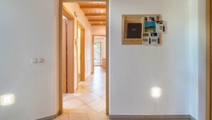 A hallway with a wooden door, a wall-mounted information board, and recessed lighting. - Apartment 'Solerhof Terrace' with Mountain View, Private Terrace and Wi-Fi (Laion)