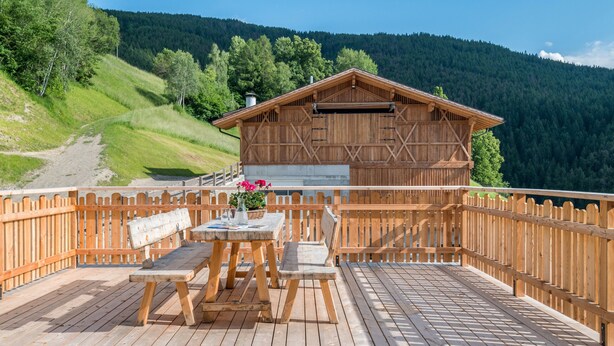 A wooden deck with a table and benches, a wooden fence, and a mountain backdrop. - Apartment 'Solerhof Terrace' with Mountain View, Private Terrace and Wi-Fi (Laion)