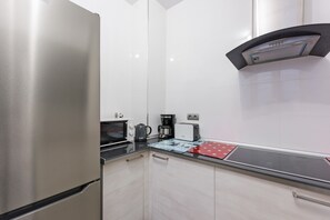 Una cocina moderna con electrodomésticos de acero inoxidable, un microondas, una cafetera y un tostador.