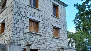 Un bâtiment en pierre doté de nombreuses fenêtres et d’une petite entrée.