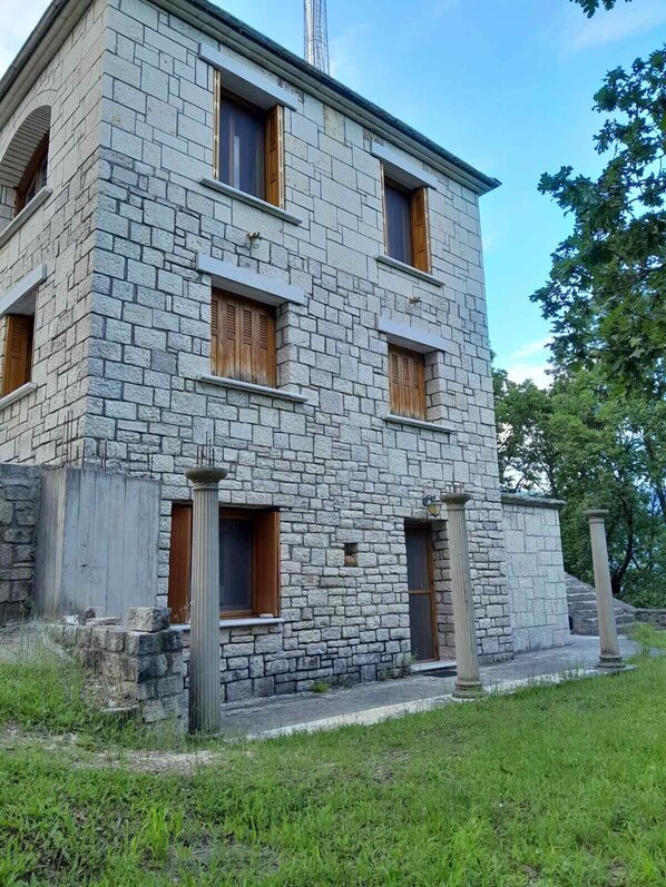 Un edificio de piedra con varias ventanas y una pequeña entrada.