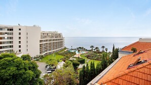 Un hotel con piscina, palmeras y vista al mar.