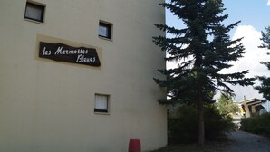 A building with a sign reading "les Marmottes Bleues" and a red mailbox.