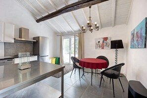 Una cocina moderna con zona de comedor, que cuenta con una isla grande, una araña y vistas al exterior.