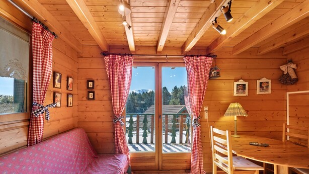 A wooden cabin with a balcony, a dining table, and a sofa. - Chalet "Maison De Bois Finlandaise" with 2 Private Terraces & Balcony (Bolquère)